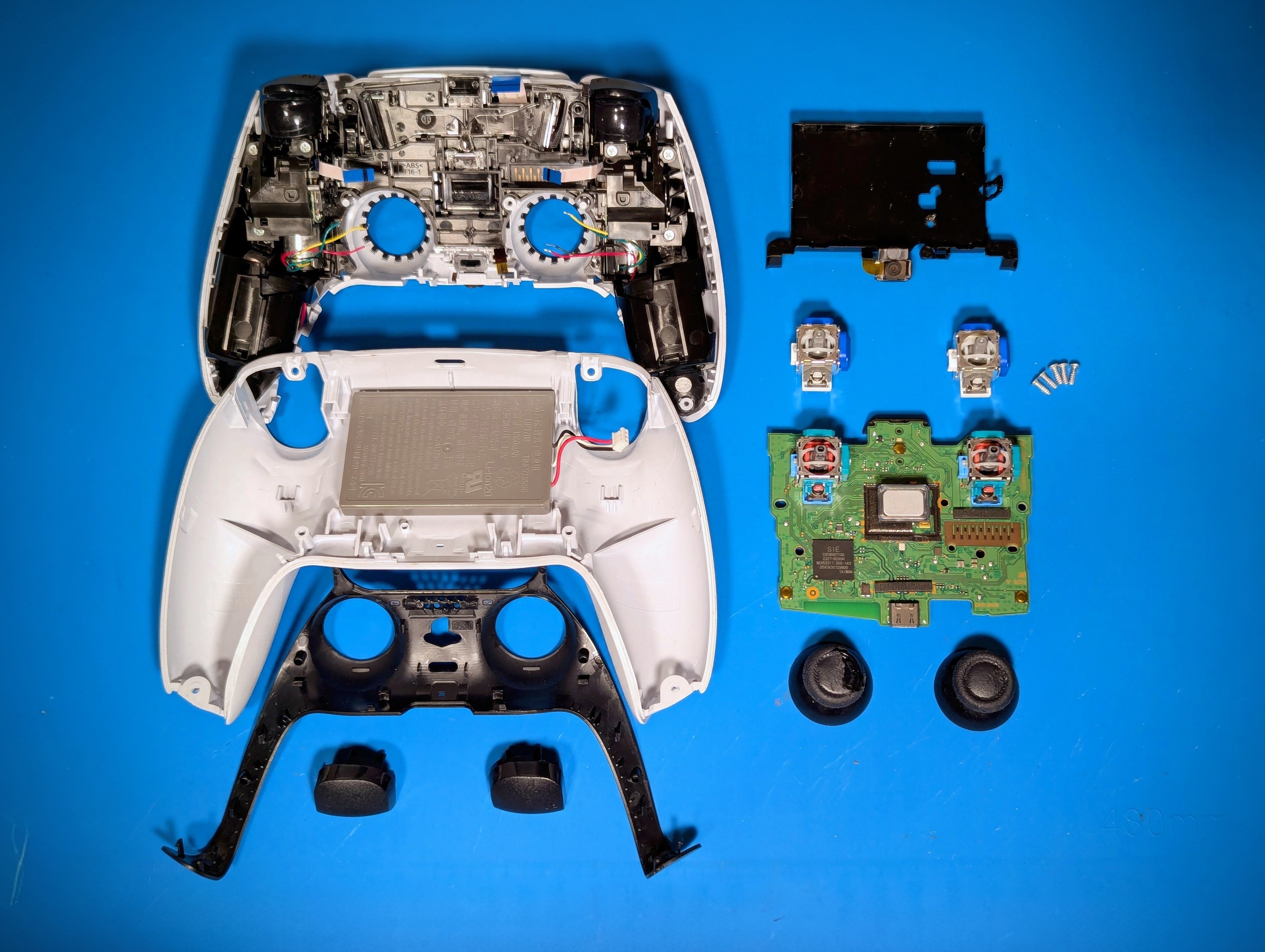 Išardytas PS5 DualSense pultelis su matomais analogų moduliais